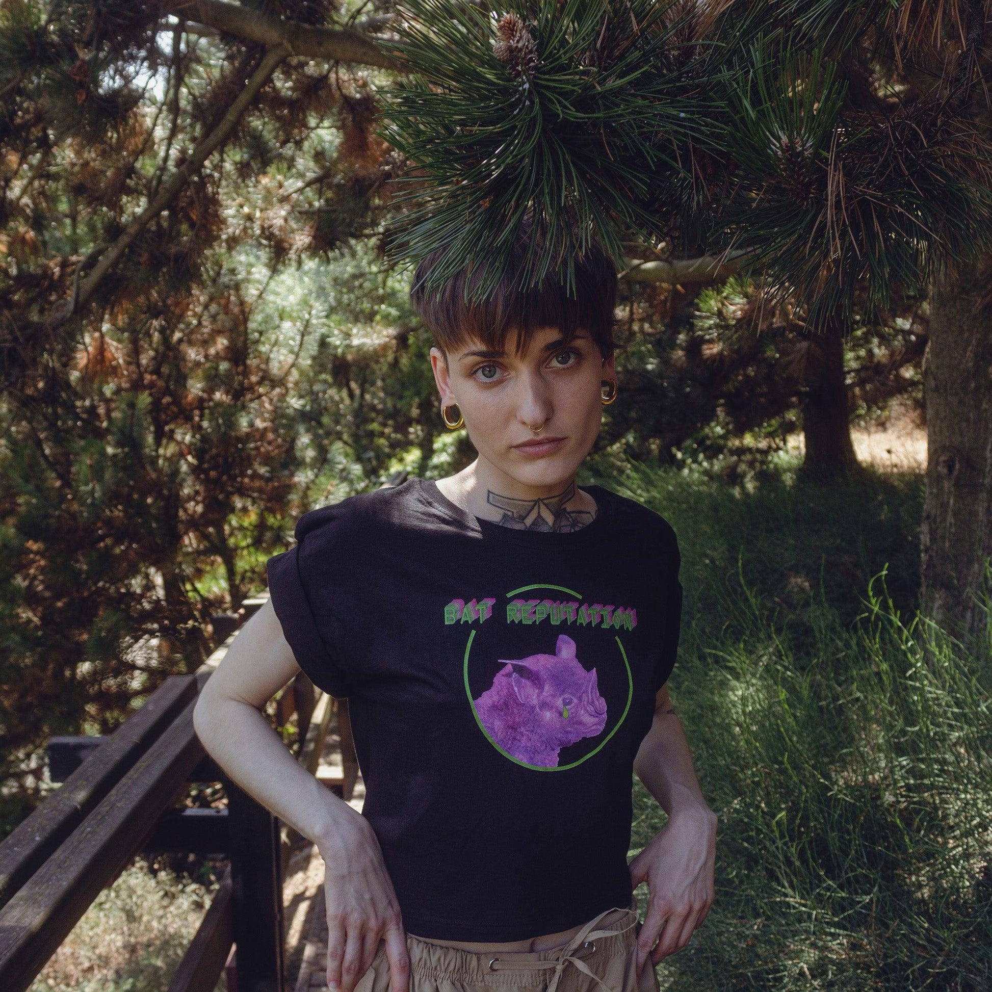 Woman model wearing Bat Reputation crop top from Chaotic Kittens in the nature.