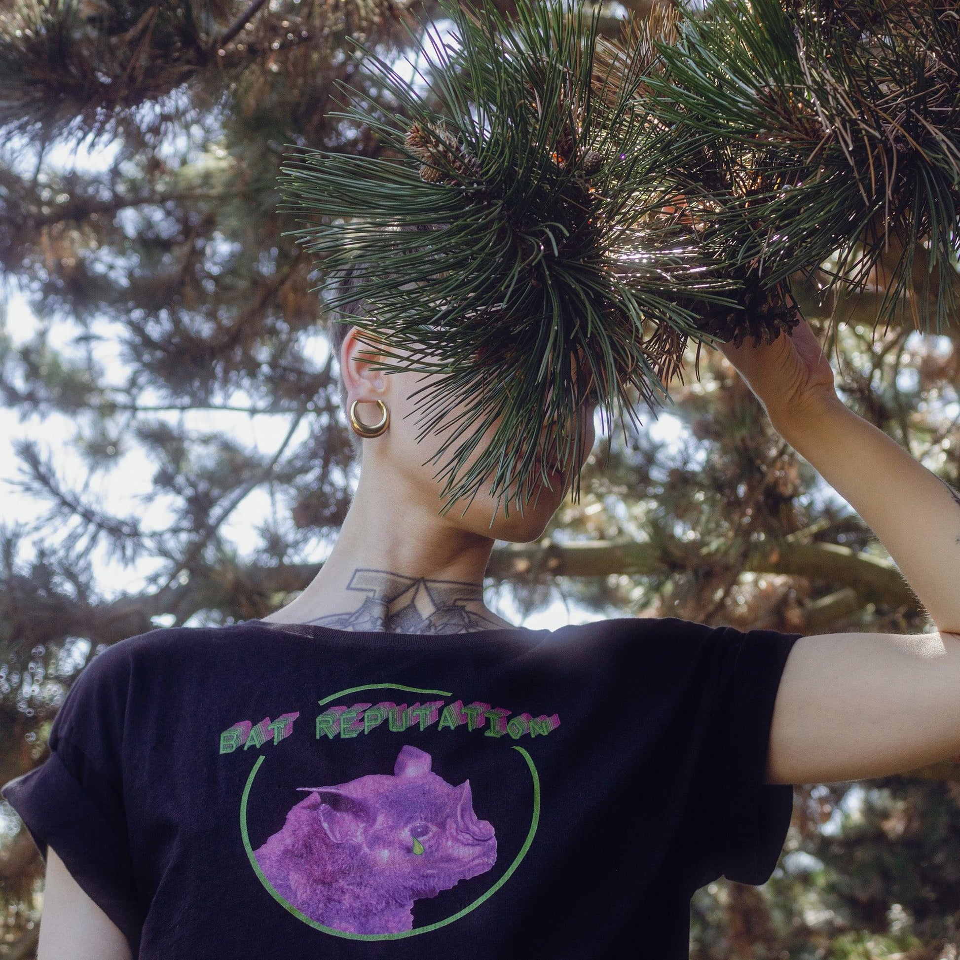 Woman model wearing Bat Reputation crop top from Chaotic Kittens in the nature.