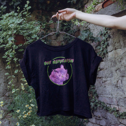 Bat Reputation crop top from Chaotic Kittens being held on a hanger in the nature.